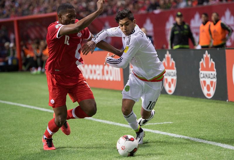 Tecatito pelea un balón durante un partido frente a Canadá