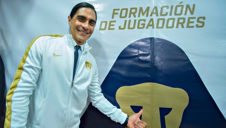 Paco Palencia posa con el escudo de Pumas a su espalda