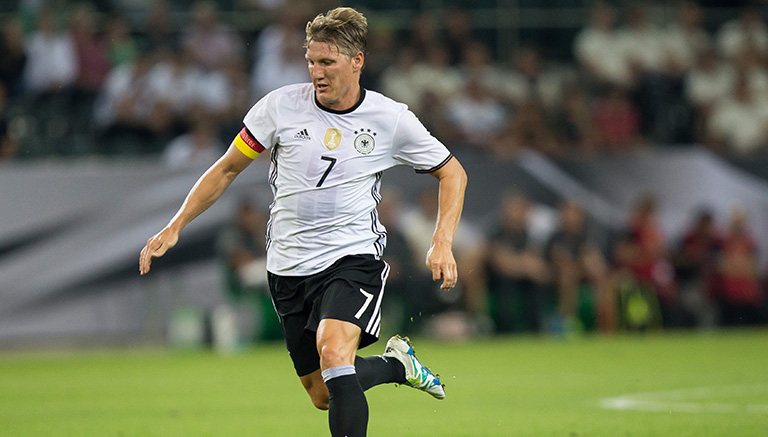 Schweinsteiger  conduce el balón en partido con Alemania