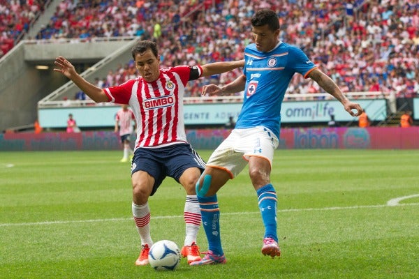 Maza Rodríguez peleando un balón con Omar Bravo