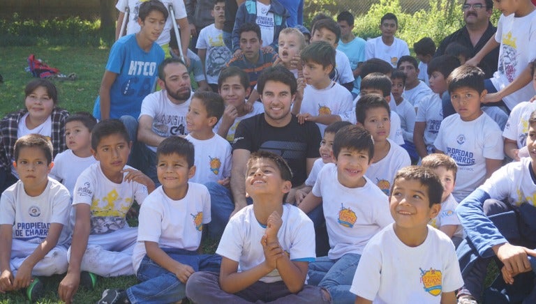 Sergio Pérez tomándose fotos con los pequeños