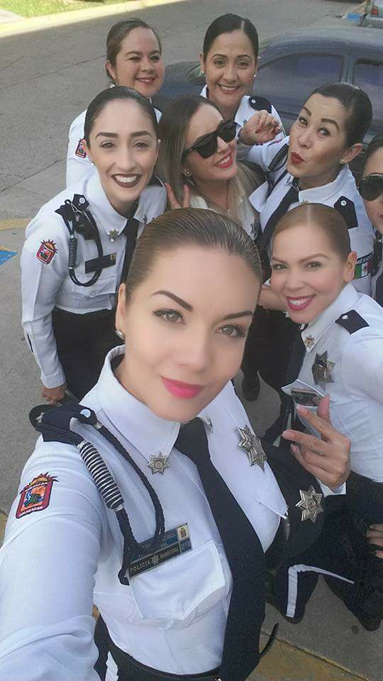 Varias policía posan en un selfie, portando sus uniformes
