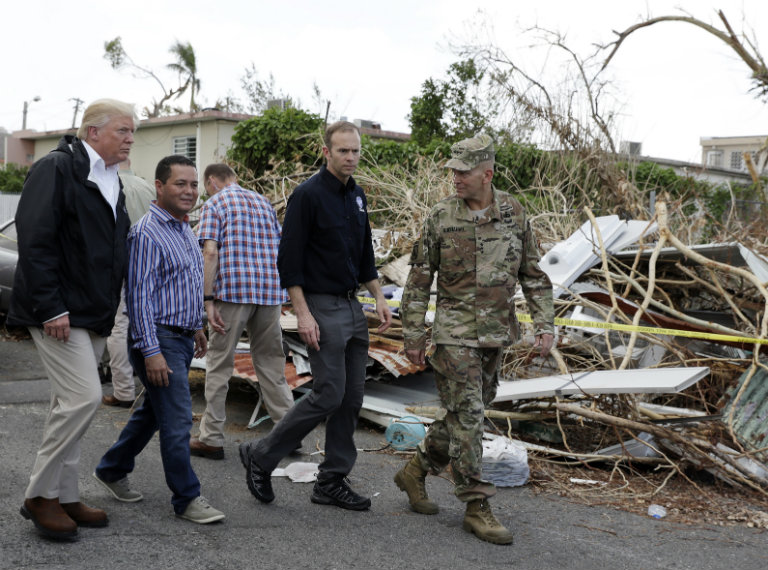 Trump caminando junto parte de su equipo en Puerto Rico