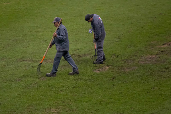 Trabajadores del Estadio Azteca revisan el terreno de juego