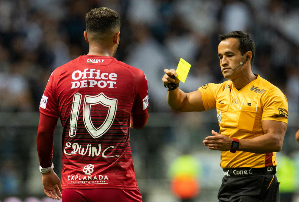 Cardona siendo amonestado durante el partido ante Rayados