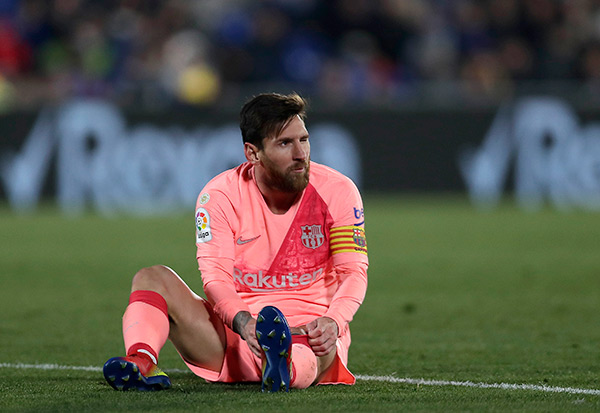 Messi, sentado en el césped durante un partido del Barcelona
