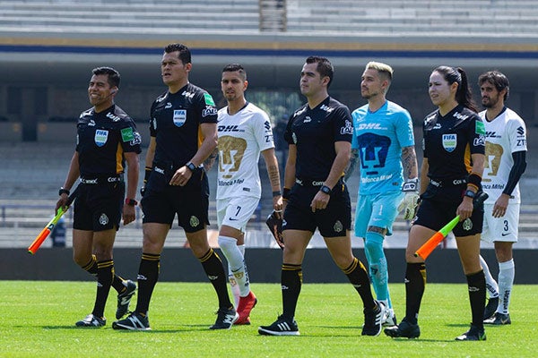 Jugadores de Pumas entran a la cancha junto al cuerpo arbitral