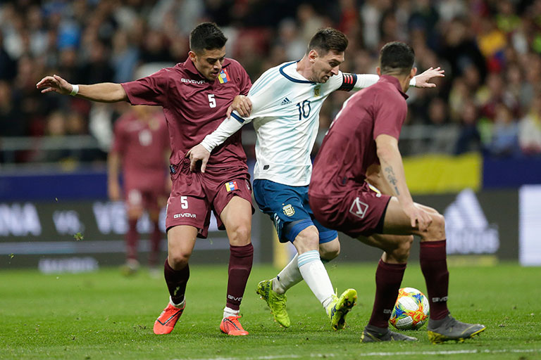 Messi es presionado por jugadores de Venezuela