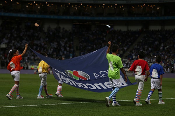 Niños entran al Estadio BBVA Bancomer con una bandera de la Liga MX