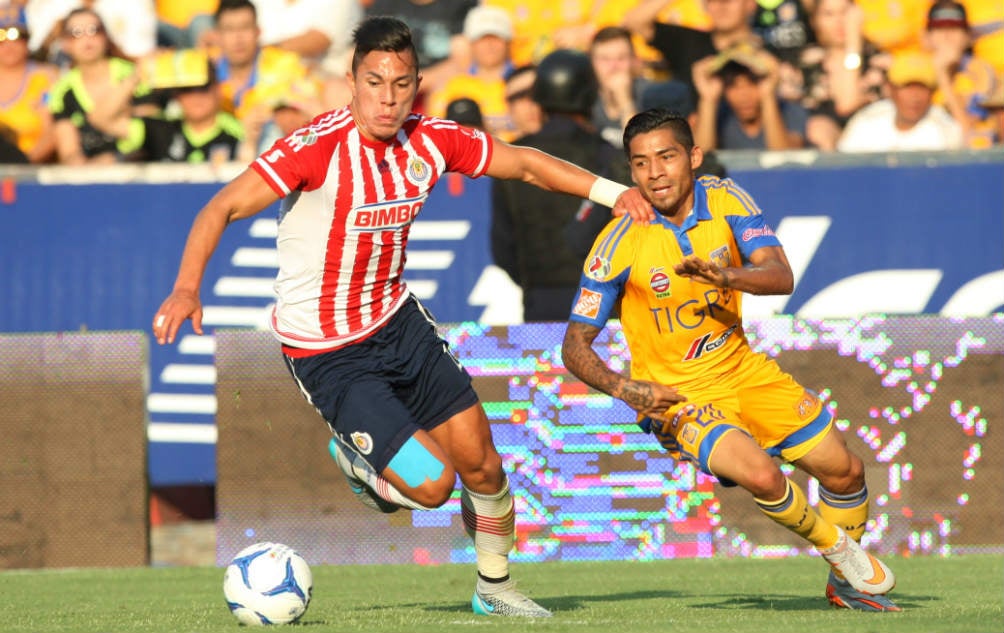 Carlos Salcedo y Javier Aquino, luchan por la pelota