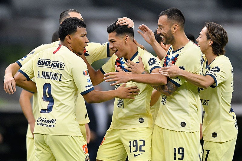 Jugadores de América celebran gol de José López