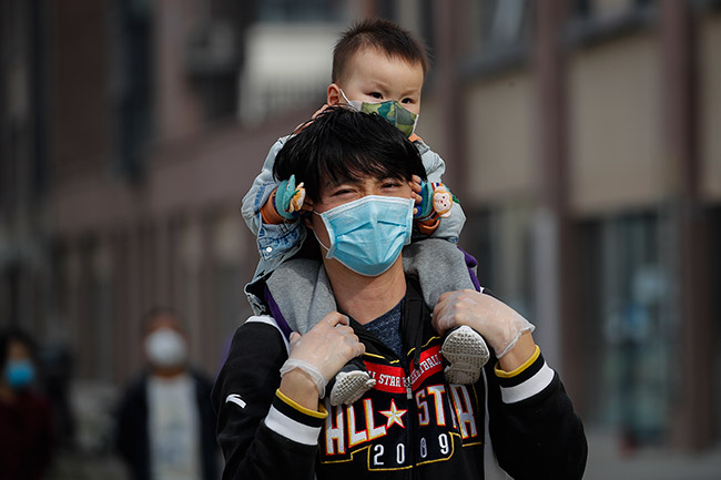 Un hombre carga a un niño en la capital de China