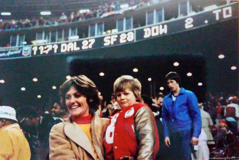 El pequeño Tom cargado por su mamá durante el partido