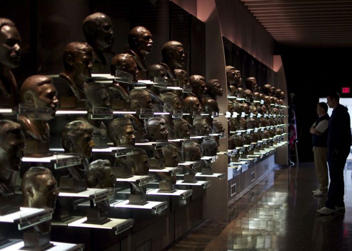 Afición observa los bustos de jugadores en el Salón de la Fama