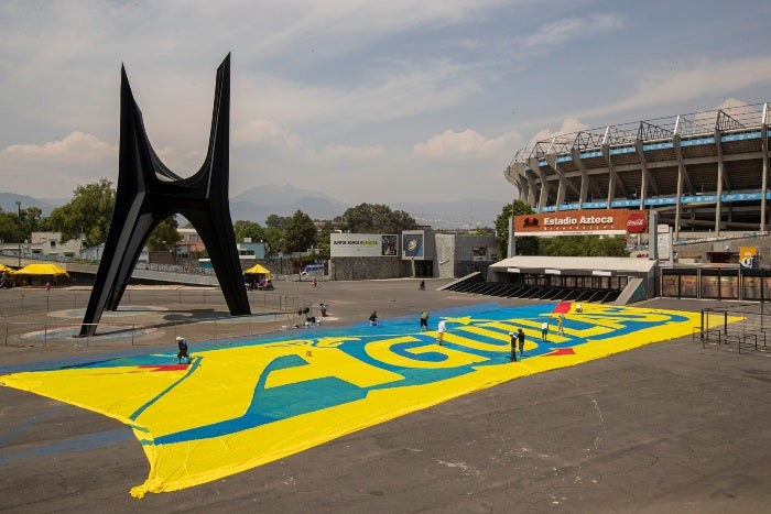 Los integrantes de la Monumental pintando la manta