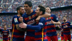Messi y Alves celebrando un tanto del uruguayo Suárez