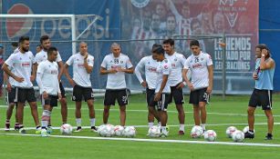 Almeyda platica con sus jugadores en un entrenamiento