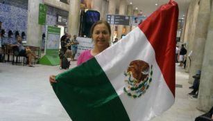 Evelia Macedo sostiene una bandera de México en apoyo a su hijo