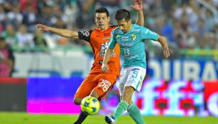 Fernando Navarro e Hirving Lozano disputan un balón en el juego León vs Pachuca