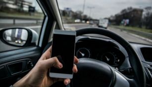 Una persona usando su teléfono mientras conduce 
