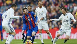 Messi intenta mandar un pase en medio de varios jugadores del Real Madrid