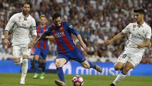 Ramos observa cómo Messi conduce el balón 