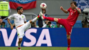 Vela disputa un balón con Smolov en el juego México vs Rusia