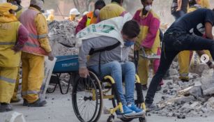Eduardo Zárate en un su silla de ruedas colaborando en la zona de desastre