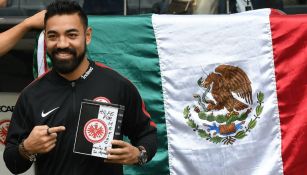 Marco Fabián sonríe con el bote de la colecta para México