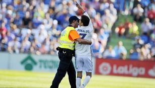 Momento en que aficionado es sacado de la cancha del Coliseum por un guardia