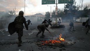 Un grupo de militares intenta apagar una fogata en las calles de Tegucigalpa