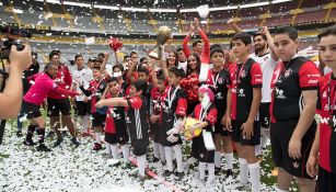 Niños posan con el trofeo en el Estadio Jalisco