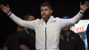 Canelo Álvarez alza manos, con motivo de victoria en conferencia de prensa