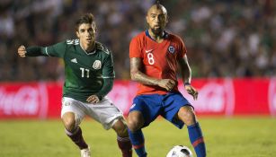 Isaac Brizuela busca quitarle el balón a Arturo Vidal 