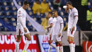 Jugadores de Chivas lamentan un gol del Puebla