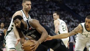 Andre Drummond recibe una falta cuando conduce entre Brook Lopez y George Hill 