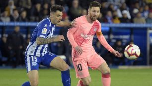 Messi intenta quedarse con el balón ante la persecución de un defensa