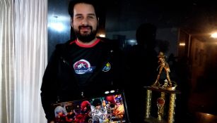 ViolentKain, posando con su joystick y el trofeo de campeón de KOF XIII que ganó en Costa Rica