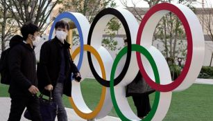 Ciudadanos de Tokio atraviesan por el monumento de los aros olímpicos