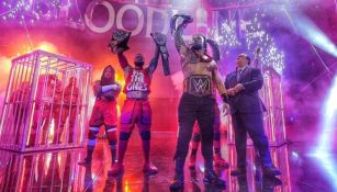 Roman Reigns levantando sus títulos de la WWE
