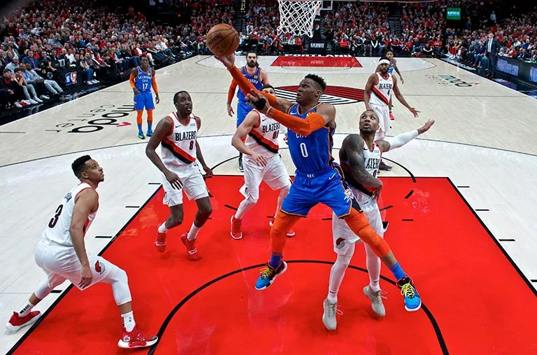 AP Russell Westbrook, en el centro, se lanza por una canasta