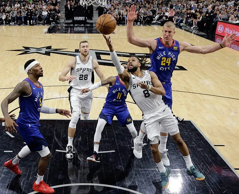 AP Patty Mills se estira para hacer una canasta