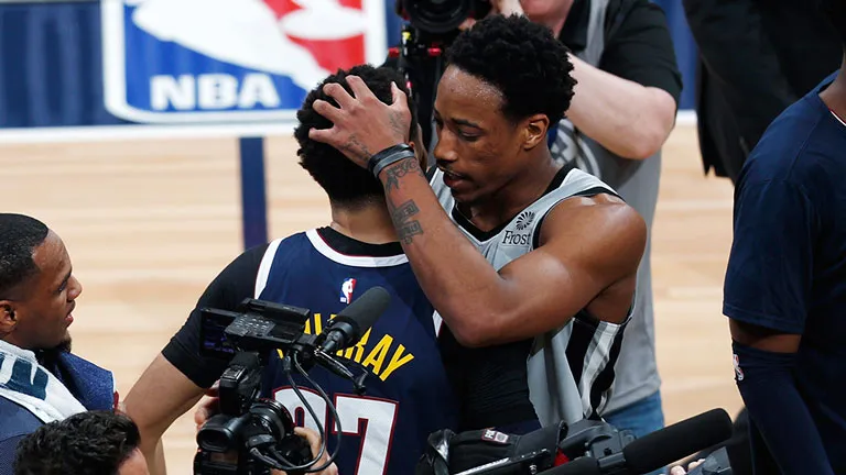 AP DeMar DeRozan abraza a Jamal Murray
