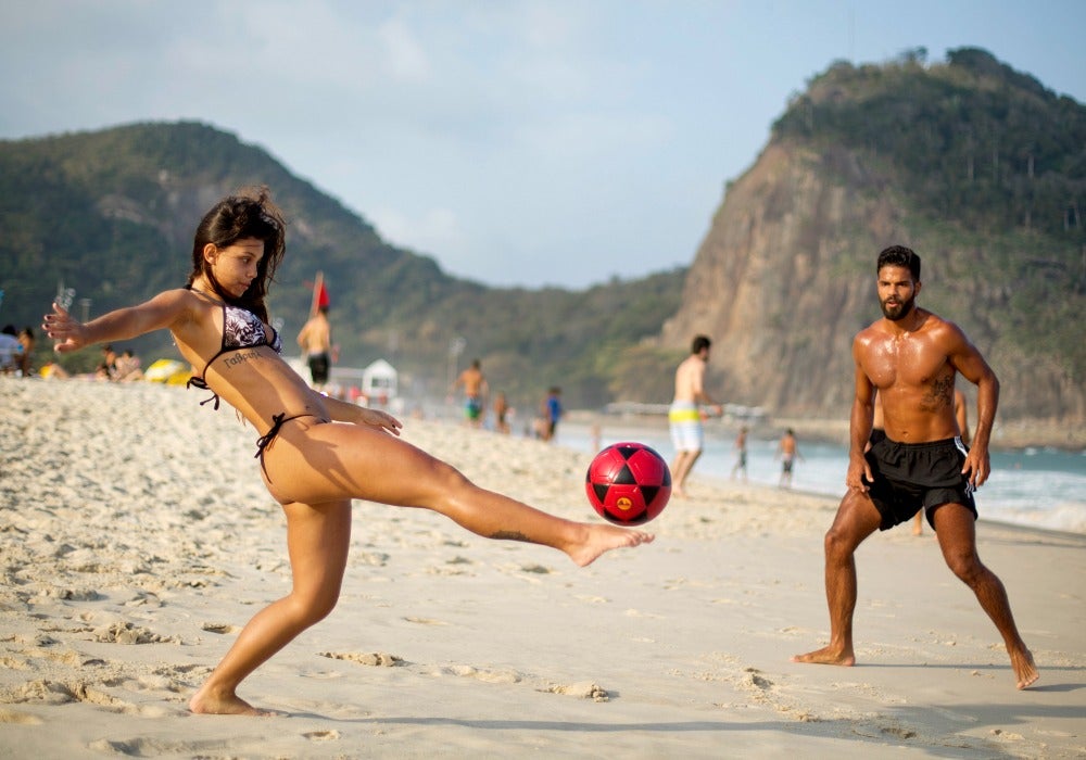 Atletas olímpicos juegan futbol en una playa de Río