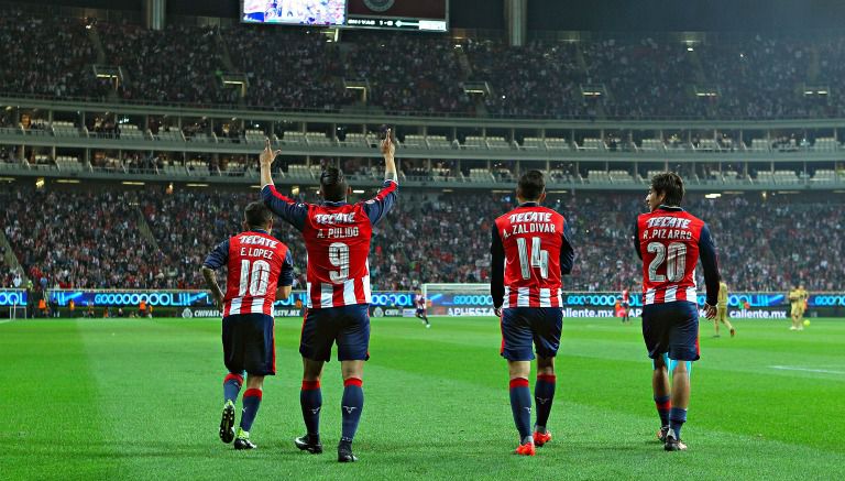 Jugadores de Chivas festejan un gol contra los universitarios