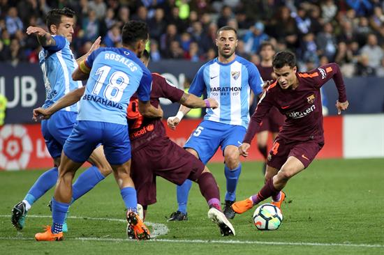 Coutinho se lleva el balón ante varios rivales del Málaga