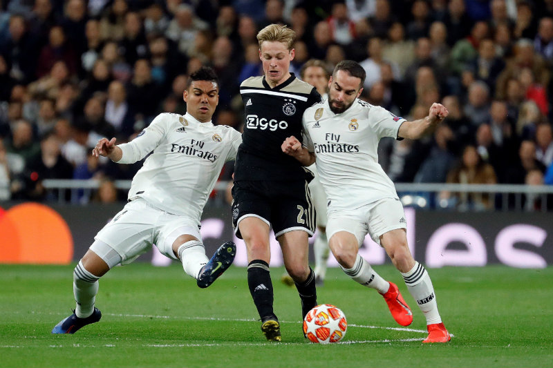 Jugadores de Ajax y Real Madrid disputan un balón