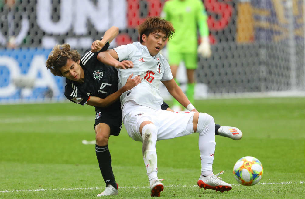 Jugadores luchan por la pelota en México vs Japón