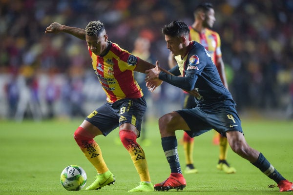 Jugadores de América y Morelia disputan un balón