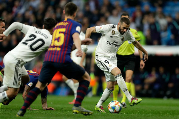 Benzema conduce el balón en un Clásico Español